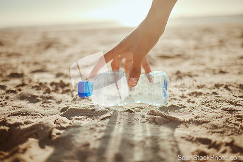 Image of Woman, hand or picking plastic bottle in beach waste management, community service or climate change volunteering. Zoom, collection worker or trash cleaning in nature sustainability or planet recycle