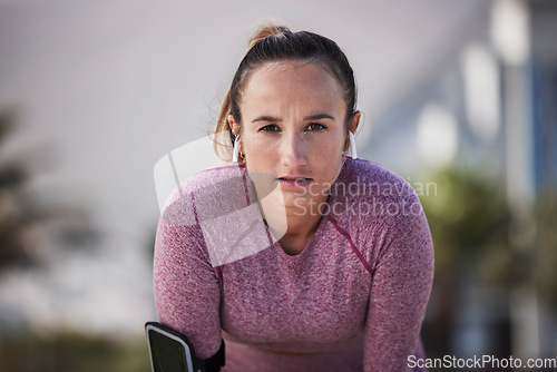 Image of Woman runner portrait, music and earphones for motivation, outdoor workout or fitness in city. Girl, wellness and focus on face with phone, streaming online or run for training, exercise or health