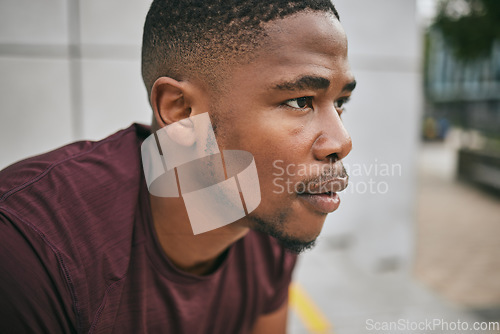 Image of Face, fitness and exercise with a black man runner breathing alone outdoor in the city for cardio or endurance. Vision, motivation and workout with a male athlete training in an urban town for health