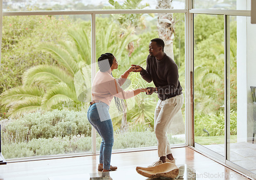 Image of Black couple, dancing and celebration in their new home with love while excited and happy in a healthy marriage. Young man and woman partner dance to celebrate in their house or apartment for fun