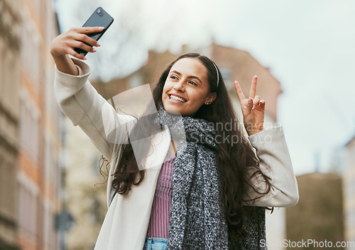 Image of Travel, peace or happy woman taking selfie for social media in London city on a relaxing holiday vacation or weekend. Smile, hand gesture or excited girl tourist taking fun pictures with pride alone
