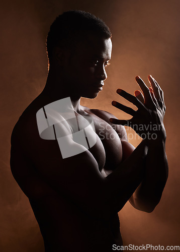 Image of Black man, muscle and dark studio with silhouette, hands and sign for art deco vision, beauty and shadow. Man, art aesthetic and smoke with strong body, alone and struggle with mental health problem