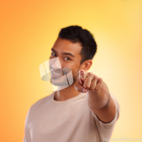 Image of Man, point and happy portrait of a person with a hand sign with orange studio background. Smile, isolated and model with blur mock up space and hands and finger gesture zoom smiling alone with beard