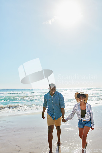 Image of Happy, laughing and black couple holding hands at the beach for love, freedom and trust in Bali. Travel, smile and black man and woman walking by the ocean during a holiday for a date in summer