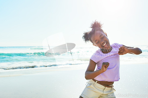 Image of Children, beach and dance with a black girl having fun alone on the sand in summer by the sea or ocean. Nature, kids and blue sky with a female child dancing by the water while on holiday or vacation