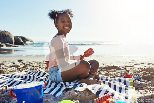 Image of Black child, smile and playing with sand at the beach for summer vacation, holiday or weekend in the outdoors. Portrait of happy African American little girl enjoying fun time with toys by the ocean