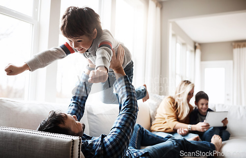 Image of Family, father and lifting child on sofa for bonding, wellness and play in happy home. Dad playing flying plane in air game with son on living room couch for care, love and bond together