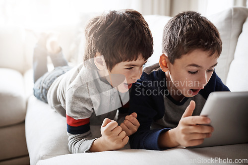 Image of Children, movies and tablet streaming for playing esports game, gaming bonding or social media in family home. Brothers, boys and kids on digital technology in house living room with wow or surprise