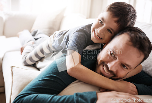 Image of Hug, fun and child playing with father on the living room sofa to relax in their family home. Happy, funny and dad and boy kid with playful affection while smiling on the couch in the lounge