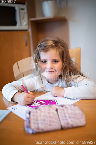 Image of cute girl painting picture on paper