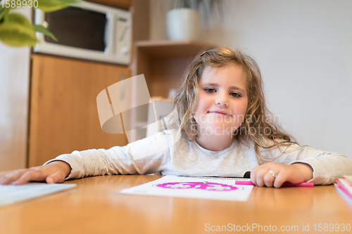 Image of cute girl painting picture on paper