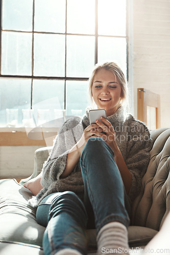 Image of Woman, sofa and phone with smile, chat and communication on internet to relax in lounge. Girl, couch and texting on social network, mobile tech or streaming video for comedy, meme and happy in house