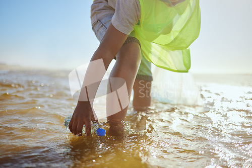 Image of Plastic bottle, cleaning ocean and kid with environment and climate change, environmental and volunteer for Earth day. Water pollution, nature and children clean up beach for eco friendly activism