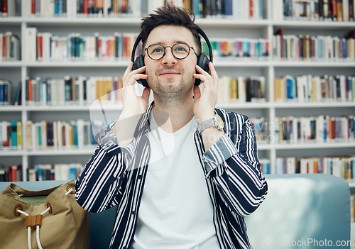 Image of Library, student and man with music headphones in university, college or school. Education, learning scholarship and face of young male streaming educational podcast, radio or song, audio or album.