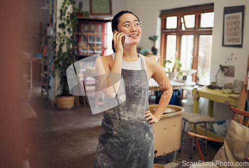 Image of Artist woman, pottery and phone call in workshop with smile, design and focus for small business. Asian art entrepreneur, conversation and smartphone with happiness, vision and thinking in studio