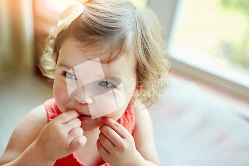 Image of Happy, baby and girl playing in her home, looking, taste and curious while biting her hand. Child, smile and child development by little girl watching, calm and content in a living room alone