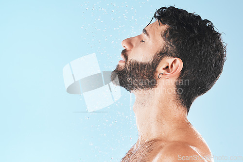 Image of Shower, man and cleaning face with water and hygiene, grooming and skincare against blue studio background. Clean, model profile with water drops and facial, natural treatment and cosmetic mockup