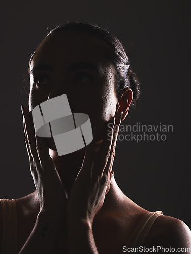 Image of Woman, beauty and face silhouette in dark fantasy, cosmetics and dream aesthetics. Shadow, black background and model headshot while touching facial skin in mystery, studio background and erotic body