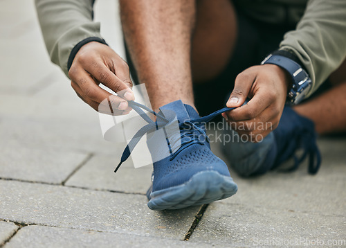 Image of Fitness, hands and black man tie shoes in city and getting ready for running, workout or exercise. Wellness, sports and male runner tying sneaker lace and preparing for training on street outdoors.
