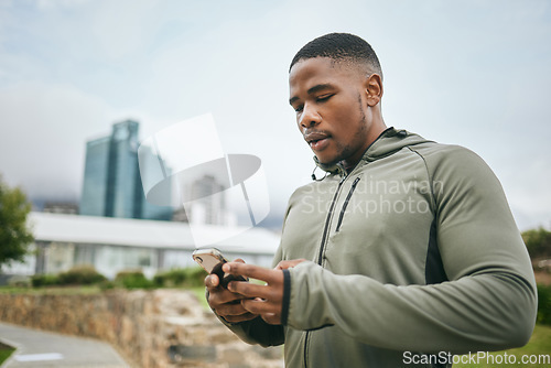 Image of Fitness, phone or black man on social media in city to relax in training, exercise or workout with in New York. Social networking, wellness or healthy athlete texting, chat or typing online on break