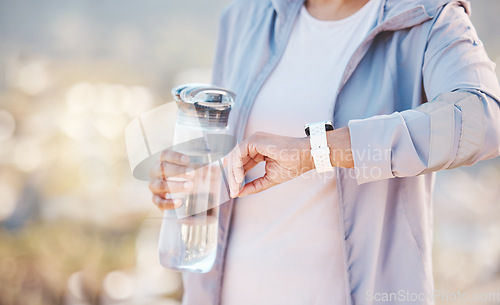 Image of Woman, runner and smartwatch check with water bottle, heart check with fitness, cardio and run outdoor for exercise. Time, monitor progress on workout and running, hydration and sport mockup