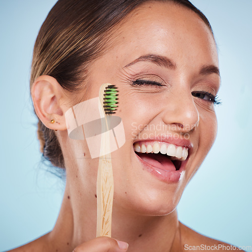 Image of Brushing teeth, dental and woman with toothbrush, wink and beauty, oral health and fresh breath with studio background. Mouth wellness, Invisalign portrait and teeth whitening with bamboo brush.