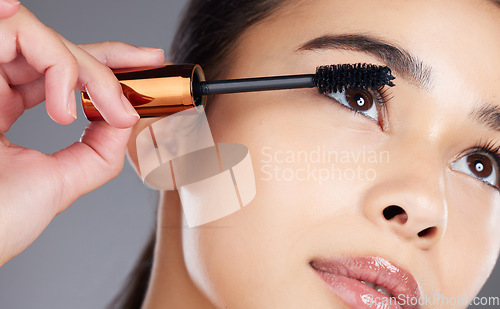 Image of Face, beauty makeup and woman with mascara in studio isolated on gray background. Cosmetics, aesthetics and closeup of young female model with brush, tool or product for care of eyelashes or wellness