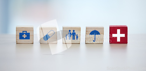 Image of Healthcare, insurance and wooden blocks in studio on an empty gray background for safety or security. Abstract, medicine and health with block toys in a hospital or clinic for medical care