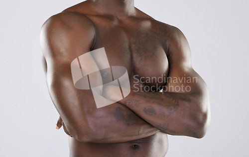 Image of Naked body, skin and black man, arms crossed and muscle, strong with fitness isolated on studio background. Muscular, bodybuilder and natural cosmetics, clean and fresh with skincare and nude