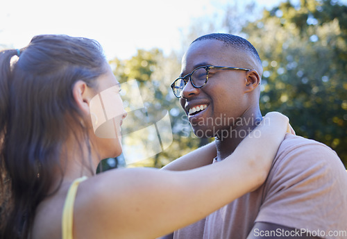 Image of Interracial couple, smile and hug for love, care or embracing relationship together in a nature park. Happy black man hugging woman and smiling in happiness for romance, embrace or support outside