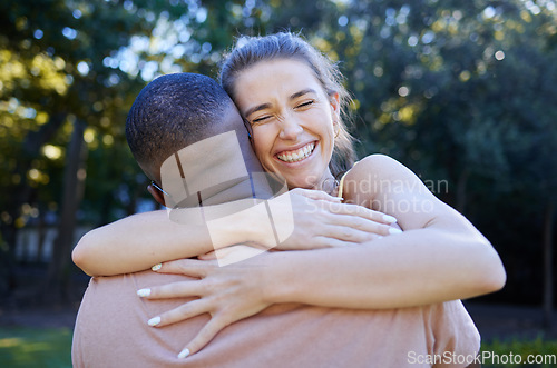 Image of Love, interracial and couple hug, outdoor and smile for bonding, romance and loving together. Romantic, black man and woman embrace in nature, relationship and happiness in park, intimate and dating