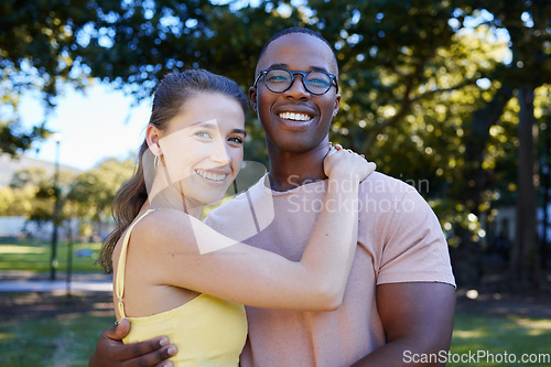 Image of Interracial, portrait and couple hug, park or smile for relationship, romance or bonding. Love, black man or woman romantic in nature, loving or happiness with embrace, dating or quality time outdoor