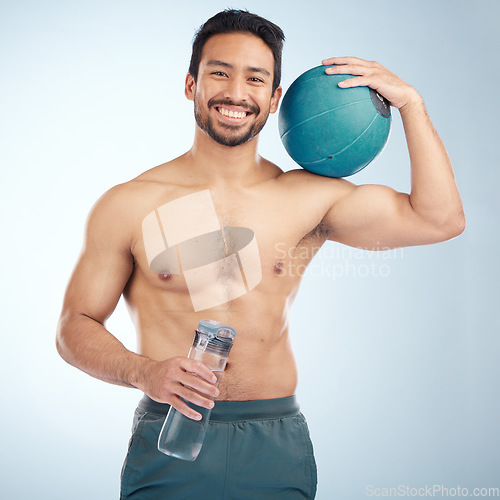 Image of Fitness, portrait and medicine ball with a sports man in studio for health or natural body. Water bottle, face and exercise with a male athlete training for a healthy lifestyle with gym equipment