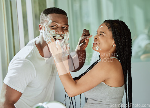 Image of Shaving, playful and fun with a black couple laughing or joking together in the bathroom of their home. Love, shave and laughter with a man and woman being funny while bonding in the morning