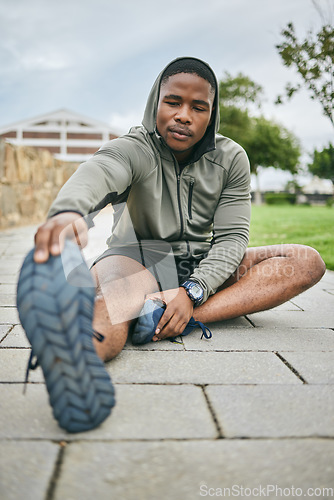 Image of Fitness, park or black man stretching in exercise for body training or workout with focus in Detroit, USA. Legs, mindset or healthy sports athlete with running goals, motivation or mission in city