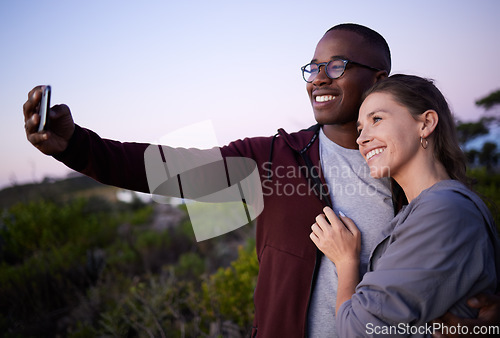 Image of Interracial couple, phone and smile for selfie, travel or adventure trip together in the nature outdoors. Happy man holding smartphone and taking a photo with woman smiling in happiness for journey