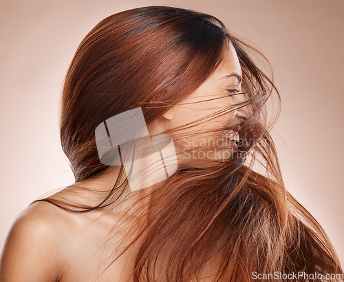 Image of Shaking hair, beauty and cosmetics of a happy woman on studio background for luxury keratin treatment with shampoo product. Headshot of female posing for salon, hairdresser and wellness mockup