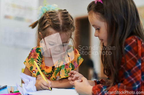 Image of Creative kids sitting in a preschool institution, draw and have fun while they get an education