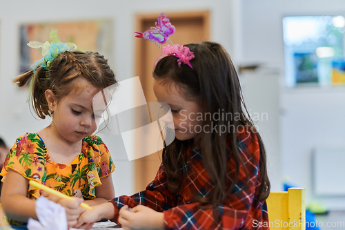 Image of Creative kids sitting in a preschool institution, draw and have fun while they get an education