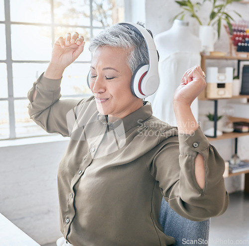 Image of Dance, headphones and music by senior business woman in office, happy and excited about small business. Earphones, dancing and elderly female celebrate in design studio, cheerful and positive at desk