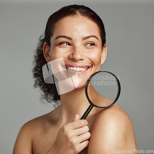 Image of Beauty, magnifying glass and woman in studio for wellness, body and skin against a grey background. Beauty, inspection and girl model relax after grooming, hygiene and cosmetic care while isolated