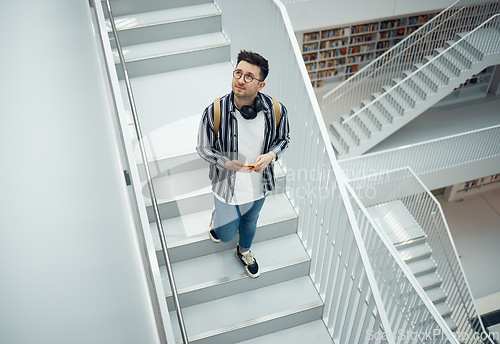 Image of Library search, geek student or intelligent man for phd research, creative vision and knowledge in university. College, stairs above and person thinking of books for education, scholarship or study