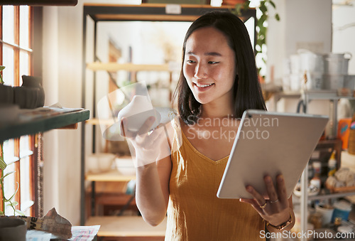 Image of Creative asian woman, tablet and smile for pottery business, checking inventory or pricing at workshop. Happy Japanese female smiling holding touchscreen with pot art for quality check or startup