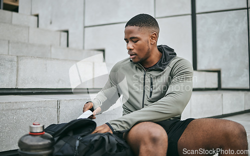 Image of Exercise, workout and black man on stairs, relax and training for fitness, wellness and health. African American male, athlete and looking in bag on steps, outdoor and sportswear for cardio or energy