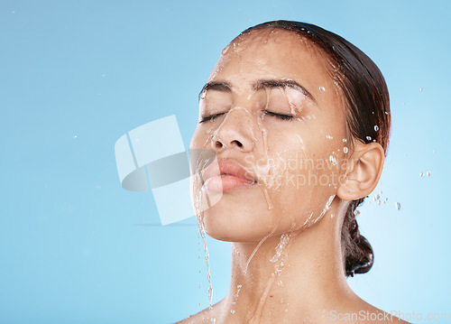 Image of Woman, face skincare or water splash on blue background studio for healthcare wellness, Brazil hygiene maintenance or self care grooming. Beauty model, showering or wet water drop for facial cleaning