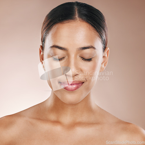 Image of Cosmetics, beauty and face of a woman with a glow from dermatology, luxury makeup and skincare on a studio background. Zen, happy and headshot of a cosmetic model with facial cosmetology wellness