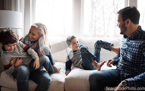 Image of Love, bonding and family on the sofa for fun, playing and playful energy in their house. Relax, happy and parents with crazy children to play wrestle on the couch during quality time in a home