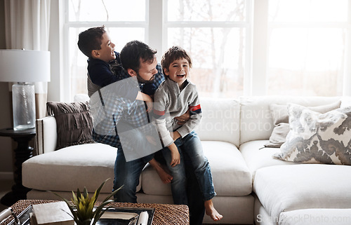 Image of Happiness, playful and father with children on the sofa for playing, quality time and crazy fun. Love, happy and boy kids piling onto their dad with energy on the couch of their family home together