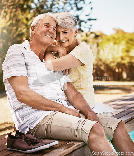 Image of Senior couple, relax and smile by pool in love and summer vacation, bonding or quality time together in the outdoors. Happy elderly man and woman relaxing and hugging by the water at a poolside