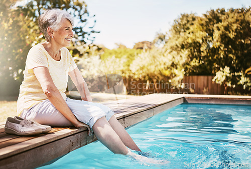 Image of Happy elderly woman with her feet in the pool while on a vacation, adventure or outdoor trip in summer. Relax, smile and senior lady in retirement by swimming pool at a holiday resort in Australia.